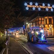 A lit-up tractor goes through Teme Street