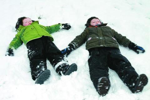 Brothers Oscar and Harvey Minton take a rest in the snow on Whitcliffe Common