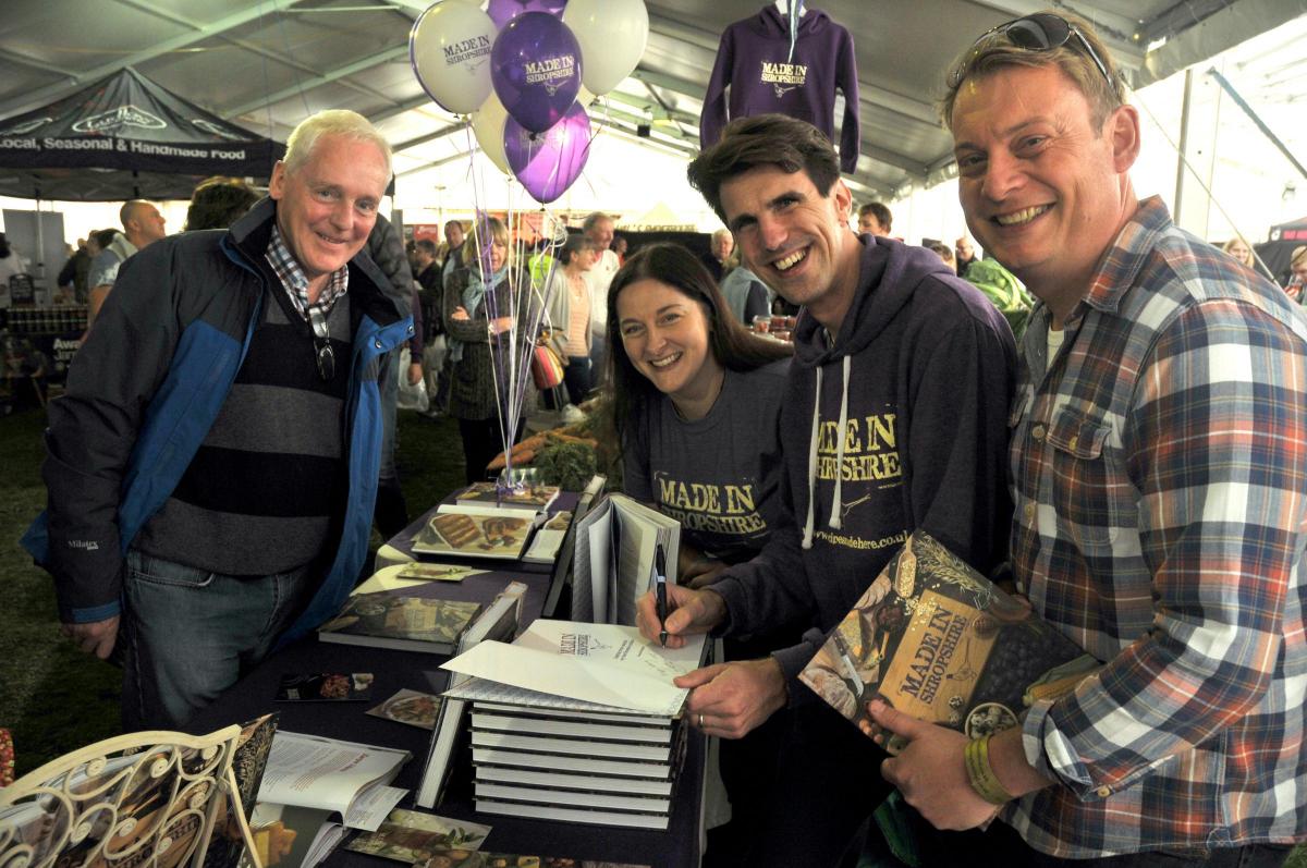 Visitor Steve Kendall has his copy of the ' Made in Shropshire' cook book signed by publisher Simon Wild and Becca Wild of Photopia Photography and Patrick Barrett of P and R Design.