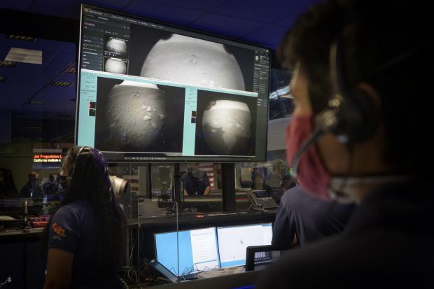 In this photo provided by NASA, members of NASA's Perseverance Mars rover team watch in mission control as the first images arrive moments after the spacecraft successfully touched down on Mars, Thursday, Feb. 18, 2021, at NASA's Jet Propulsion
