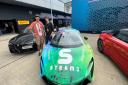 Prof Brian Cox with STEAM Co's Nick Corston and branded McLAren supercar in the Pits at the British Grand Prix