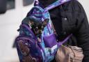 A woman fleeing Ukraine carries a small dog in a backpack on the border in Vysne Nemecke, Slovakia,  (AP Photo/Darko Vojinovic).