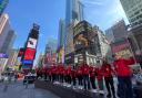 The group from Vision Arts Academy and Ludwig Theatre Arts line up for a photoshoot in Times Square, New York.