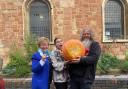 Celia Adams delivers the largest pumpkin to Amy Edwards and Chewie Beard at Maggs Day Centre in Worcester