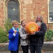 Celia Adams delivers the largest pumpkin to Amy Edwards and Chewie Beard at Maggs Day Centre in Worcester