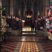 The singers at St Michael's with the church's famous knitted Christmas tree in 2021