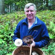 John Hughes with a selection of fungi collected, including a parasol mushroom and an old puff ball.